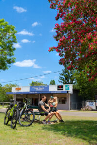 Cyclists resting outside the Brisbane Valley Rail Trail Cycles store in Moore