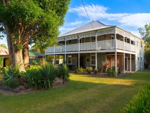 Front view of the two story Queenslander Montrose on Moore. A large tree is out the front.