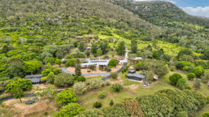 Aerial View of The Archer Retreat accommodation venue surrounded by greenery, with a mountain background