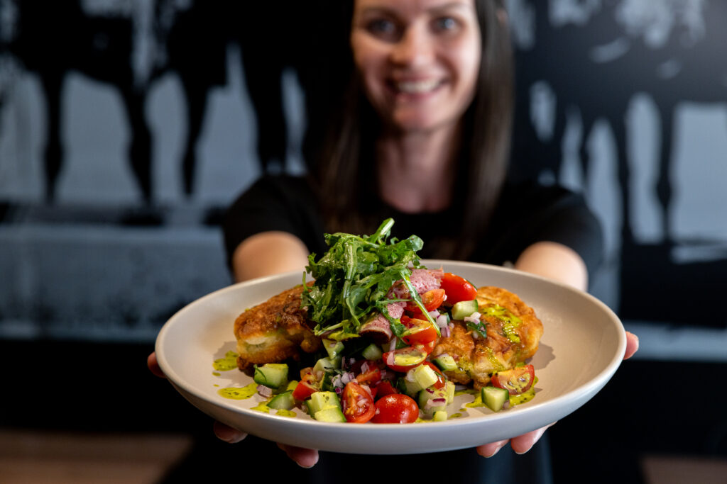 Splityard Social Fritters in a bowl held out by a worker