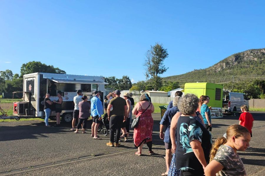 People lined up at the Food Trucks in Esk for Friday Night Food Trucks, with clear blue sky and part of Mount Glen Rock in the background