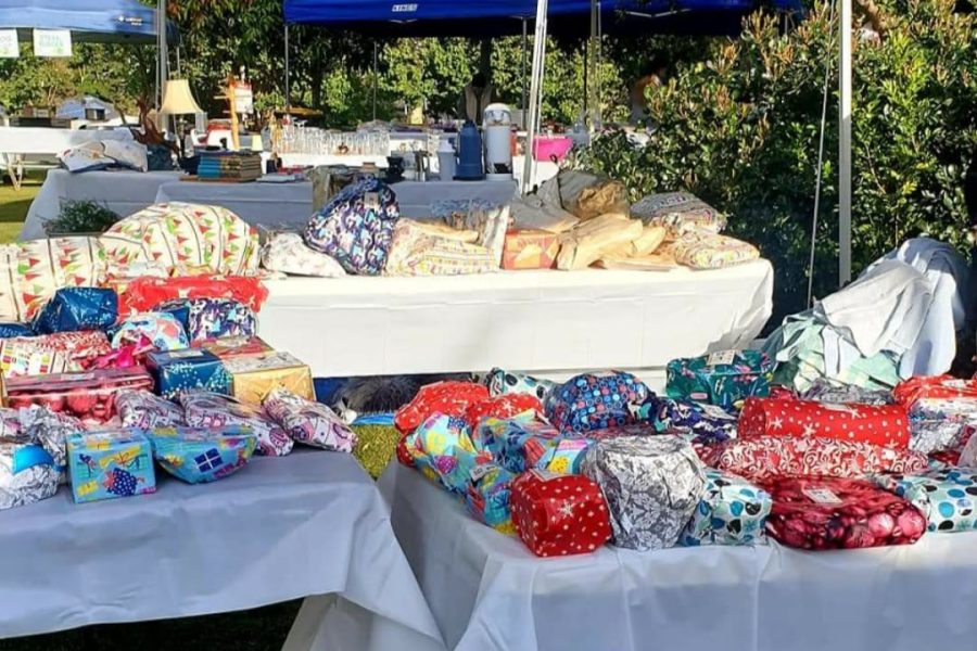 Market stalls - tables under marquees with a range of brightly coloured wrapped parcels on the tables for the pick a parcel stall.