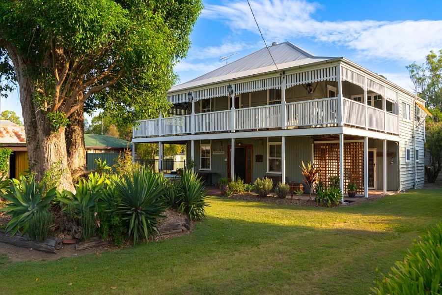 Front view of the two story Queenslander Montrose on Moore. A large tree is out the front.