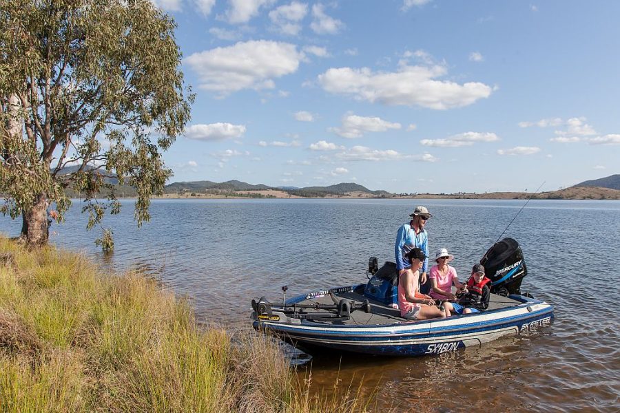 Family enjoying a day out on Lake Somerset in a small powerboat. They are just approaching the shoreline .