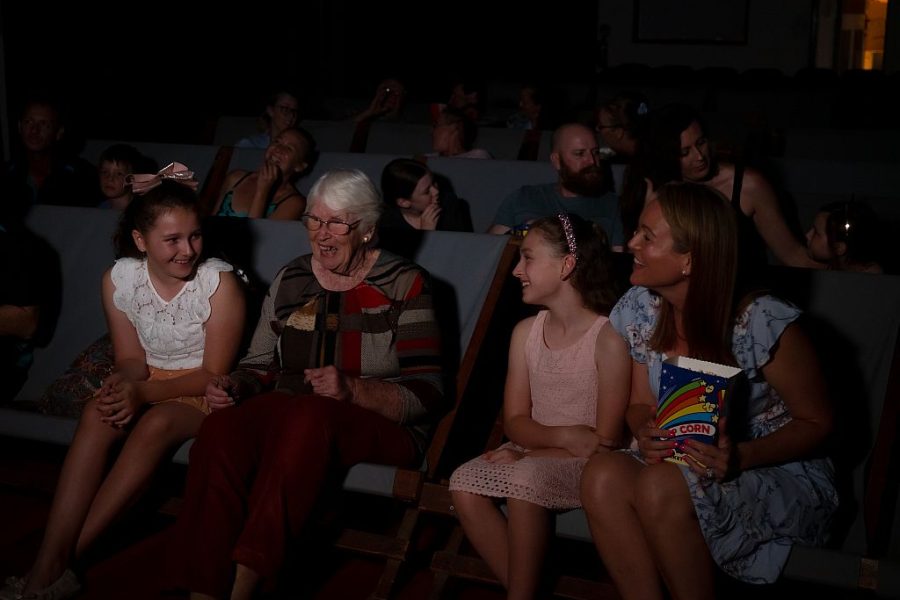 Family with grandmother, mother and two daughters watching the movie in old style sling back chairs at the Toogoolawah Pictures